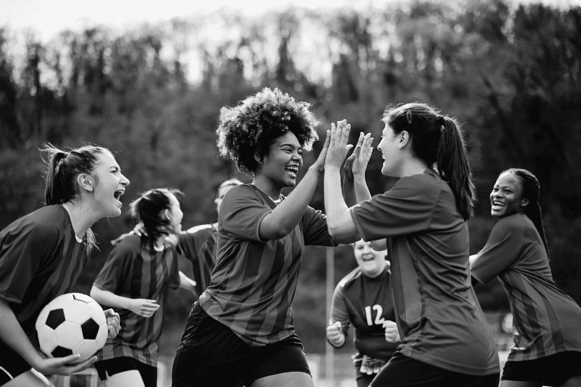 Joyeuse équipe féminine de football célébrant sa victoire après avoir joué un match au stade