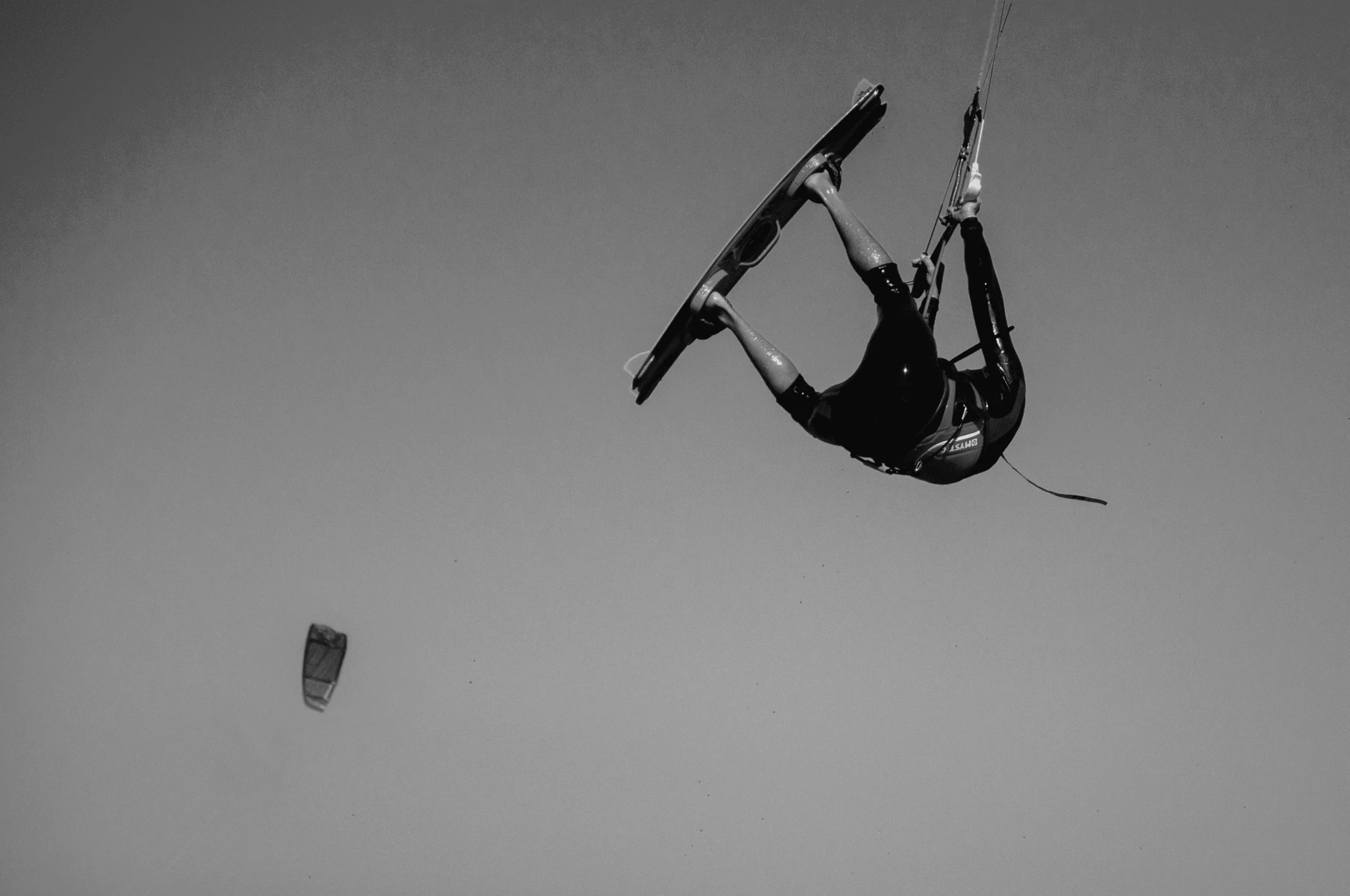 Kite surf. Un kitesurfeur vole sur sa planche dans les airs entouré de cerfs-volants de traction
