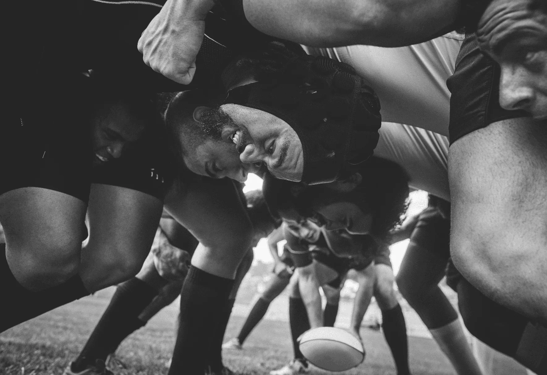 Plan à angle bas de deux jeunes équipes de rugby s'affrontant dans une mêlée lors d'un match de rugby sur un terrain