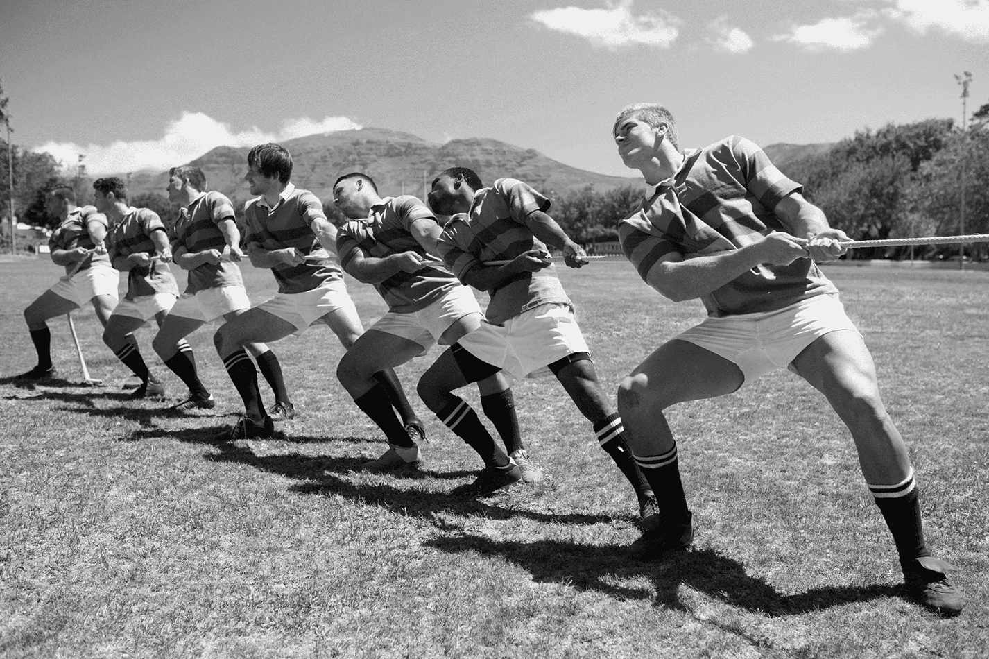 Pleine longueur de joueurs de rugby jouant au remorqueur de la guerre sur terrain herbeux
