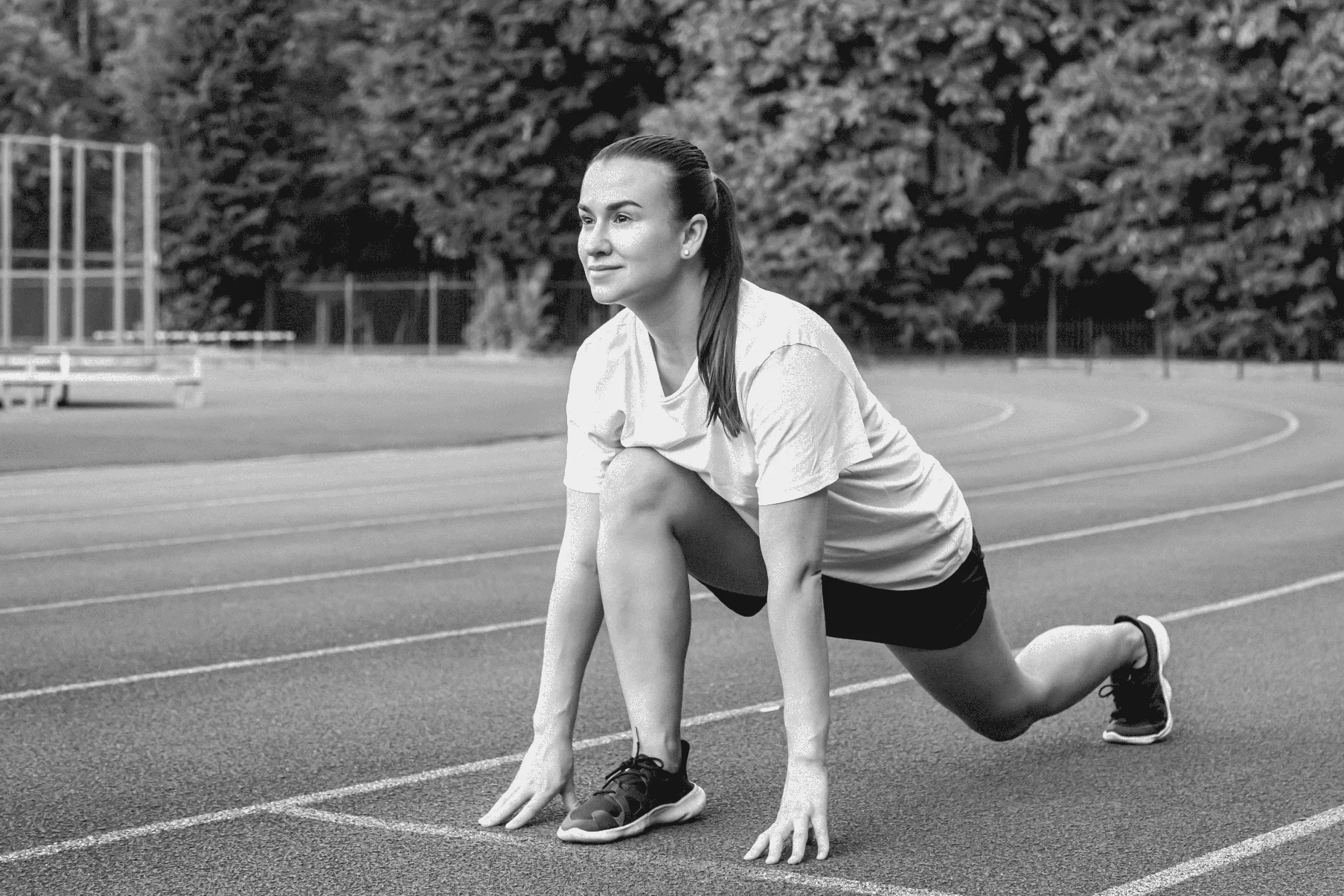 Une jeune coureuse en position de départ sur une piste de course pendant l'entraînement