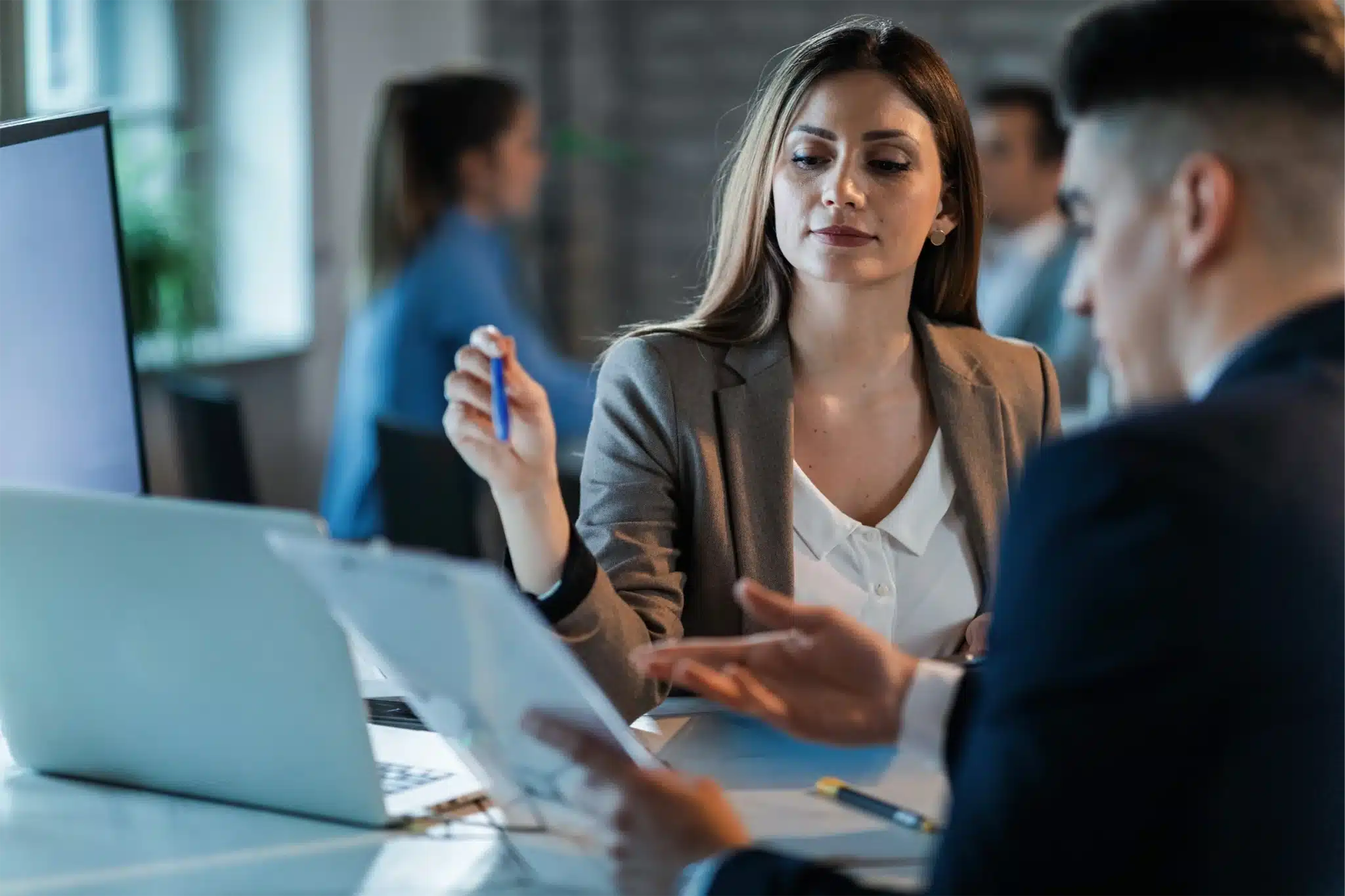 Deux collaborateurs du secteur bancaire et de l'assurance analysant un document de travail, illustrant l'impact positif de la formation DDA sur la performance en entreprise.